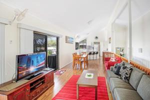 a living room with a tv and a couch at 40 Rumbalara Avenue Rainbow Beach in Rainbow Beach