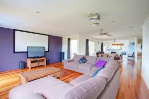 a living room with two couches and a flat screen tv at 29 Cypress Avenue Rainbow Beach in Rainbow Beach