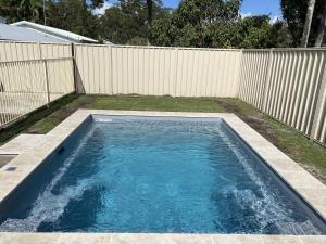 a swimming pool in a backyard with a fence at 10 Coora Court Rainbow Beach in Rainbow Beach