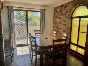 a dining room with a wooden table and chairs at 10 Coora Court Rainbow Beach in Rainbow Beach