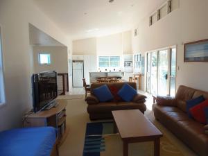 a living room with leather couches and a tv at COOLAMAINE 2 Rainbow Beach in Rainbow Beach