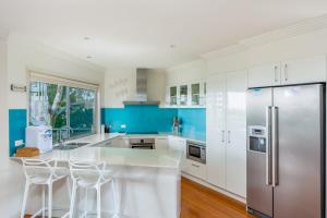 a kitchen with white cabinets and a stainless steel refrigerator at Rainbow Towers 4 Rainbow Beach in Rainbow Beach