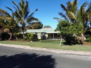 a house with palm trees in front of a street at Palmgrove 2 Rainbow Beach in Rainbow Beach