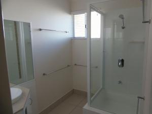 a bathroom with a glass shower and a sink at Palmgrove 2 Rainbow Beach in Rainbow Beach