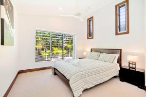a bedroom with a large bed and a window at Geckos Rest Rainbow Shores in Rainbow Beach