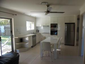 a kitchen with a table and chairs and a refrigerator at Palmgrove 1 Rainbow Beach in Rainbow Beach
