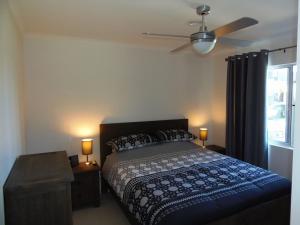 a bedroom with a bed and a ceiling fan at Palmgrove 1 Rainbow Beach in Rainbow Beach
