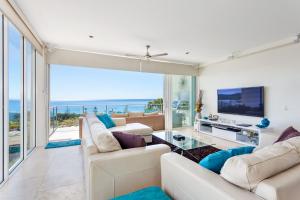 a living room with white furniture and a large window at Dees Retreat Rainbow Beach in Rainbow Beach