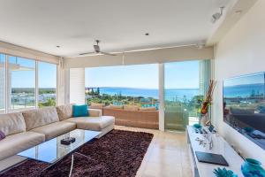 a living room with a couch and a large window at Dees Retreat Rainbow Beach in Rainbow Beach