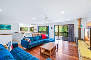a living room with blue couches and a table at Barnys Rainbow Beach in Rainbow Beach