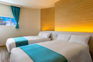 a hotel room with two beds and a window at HOTEL Gran Arenaホテルグランアリーナ in Okinawa City