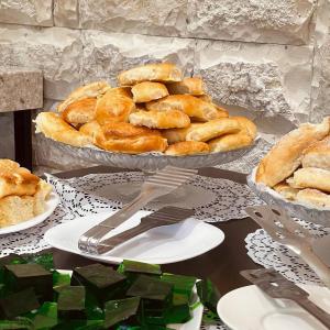 una mesa con platos de bollería y un tazón de pan en Abaash Hotel Afon, en Novi Afon