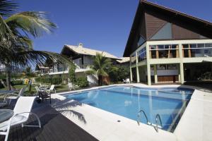 una casa con piscina frente a una casa en Pousada Morada do Guaruça, en Bombinhas