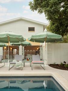 a pool with two chairs and two umbrellas at The Isla in Batemans Bay