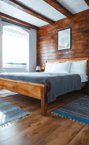 a bed in a room with a wooden wall at CASA HINTZ Transilvania in Făgăraş