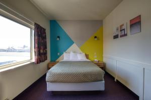 a hotel room with a bed and a window at Western Motel in Shamrock