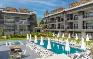 a hotel with a swimming pool with chairs and umbrellas at A Suite Side in Side