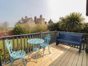 een terras met twee stoelen en een tafel en een bank bij Sea View Lodge in Morpeth