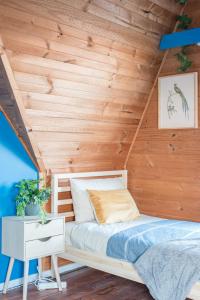 a bed in a room with a wooden ceiling at Rustic Private Room in Waterfront Beach Retreat 8 - SHAREHOUSE in Sydney