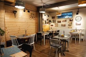 a restaurant with wooden walls and tables and chairs at CASA HINTZ Transilvania in Făgăraş