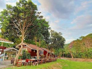 a resort with tables and chairs in the grass at ผาผึ้ง Neverland in Ban Wang Krathon (1)