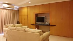 uma sala de estar com um sofá e uma televisão em Tropical Sea View & Sunshine em Batu Ferringhi