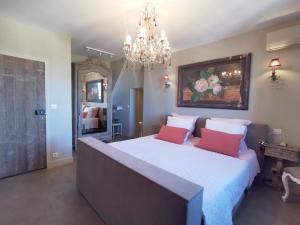 a bedroom with a large bed with two red pillows at Le Petit Chateau in Châteauneuf-de-Gadagne