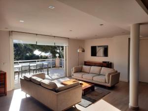 a living room with two couches and a balcony at CASSIS Plage & Calanques in Cassis