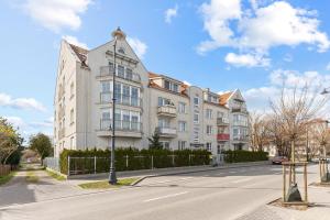 un grand bâtiment blanc sur le côté d'une rue dans l'établissement Lion Apartments - Bosman I, à Sopot