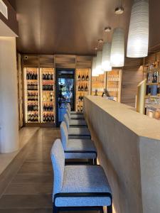 a bar with blue chairs and a counter with wine bottles at Alevic Hotel Sirmione in Sirmione