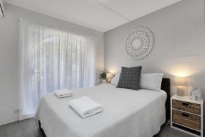 una camera da letto con un letto bianco con due asciugamani sopra di 14 The Islander Resort a Point Lookout