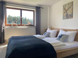 1 dormitorio con cama y ventana con un perro en el alféizar de la ventana en Ferienhof Steingaden en Steingaden