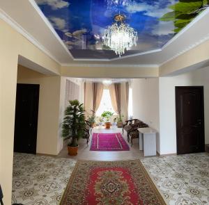 ein Wohnzimmer mit einem Kronleuchter und einem roten Teppich in der Unterkunft Отель Жылдыз in Jalal-Abad