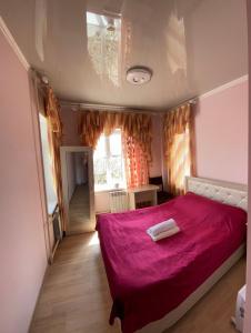 ein Schlafzimmer mit einem roten Bett mit einer roten Decke in der Unterkunft Отель Жылдыз in Jalal-Abad
