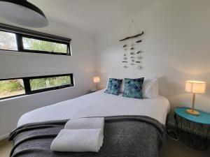 a bedroom with a large white bed with two pillows at Bella Blue - Scamander River Stay in Scamander