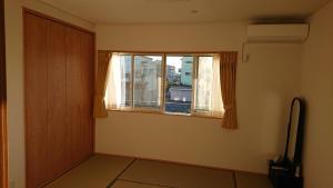 an empty room with a window and a door at Guesthouse Gifu SUAI in Gifu