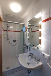 biała łazienka z umywalką i prysznicem w obiekcie Landschloss Korntal w mieście Korntal-Münchingen