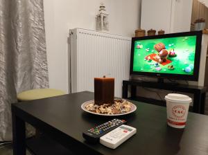 una mesa con un plato de comida y una vela y un mando a distancia en Dreams 2, en Karditsa