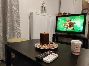 a table with a plate of food and a candle and a remote control at Dreams 2 in Karditsa