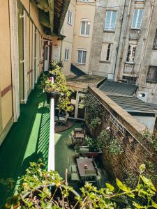 a balcony with tables and chairs in a building at Garden Hotel Rennes Centre Gare in Rennes
