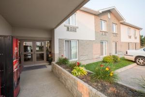 a house with a garage and a driveway with flowers at The Village Inn in Elora