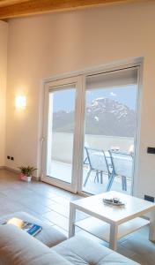 ein Wohnzimmer mit einer großen Glasschiebetür und einem Tisch in der Unterkunft Attico Bella Vista in Dubino