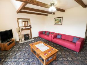 een woonkamer met een rode bank en een salontafel bij Bay View Cottage in Whitby