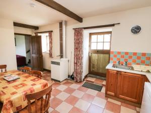 een keuken en eetkamer met een tafel en een wastafel bij Bay View Cottage in Whitby