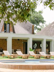a group of lounge chairs next to a house at Lilayi Lodge in Lusaka
