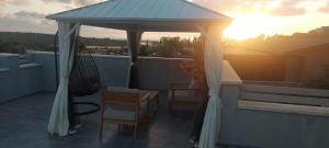 einen Pavillon mit einem Tisch und Stühlen auf dem Dach in der Unterkunft סוויטה הילה במצובה in Maẕẕuva