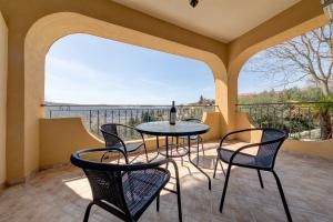 - une table et des chaises sur un balcon avec une bouteille de vin dans l'établissement Apartments Casa Bella, à Kotor