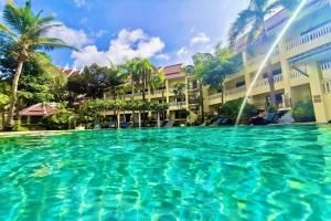 a large swimming pool in front of a building at MW Krabi Beach Resort -Family run- SHA Extra Plus in Ao Nang Beach