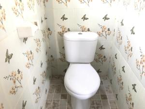 a bathroom with a toilet with butterflies on the wall at Kabera Bungalow Ubud in Ubud +40 photos