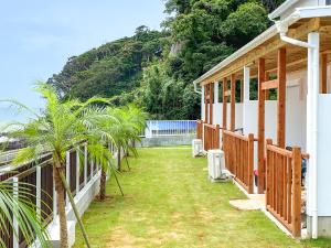 una casa con una palma nel cortile di KR バーズ ヴィラ伊豆白浜リゾート a Shimoda